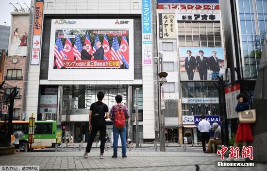 資料圖：2018年6月，在日本東京的一個廣場，人們通過戶外大屏幕觀看朝美領導人首次會晤的直播畫面。