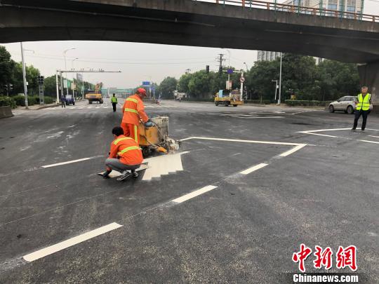 工作人員給事發(fā)路段的地面噴上白色的交通標(biāo)線。 孫權(quán) 攝