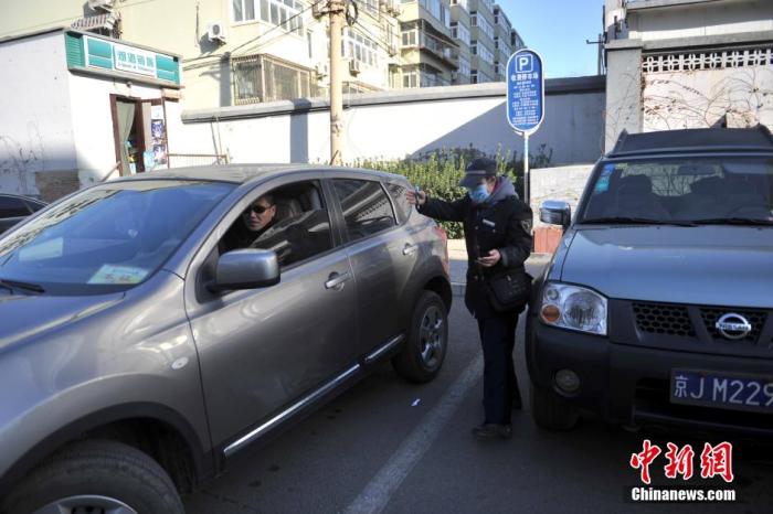 北京市某停車場(chǎng)管理員為車主指揮倒車。<a target='_blank'  >中新網(wǎng)</a>記者 金碩 攝
