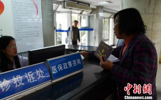 資料圖。一名女子在醫(yī)保政策咨詢臺前咨詢。 王思哲 攝