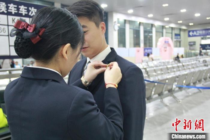 圖為朱益嘉為丈夫齊紹華志愿服務(wù)前整理著裝 。廣州車務(wù)段供圖